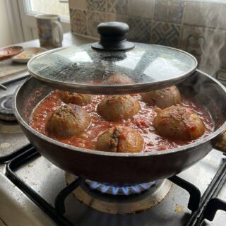 בצלים ממולאים באורז מתבשלים בסיר על הכיריים